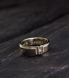 a close up of a wedding ring on a wooden surface