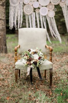 a chair with flowers on it in front of a string and tassels decoration