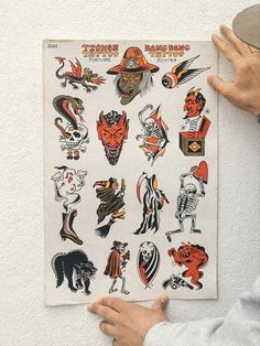 a person holding up a poster with various tattoos on it