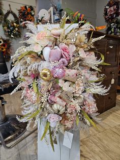 a vase filled with lots of flowers on top of a table