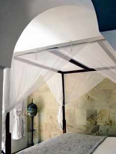 the canopy bed is made up with white drapes