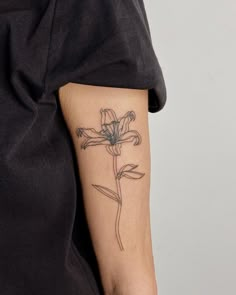 a woman's arm with a flower tattoo on the left side of her arm