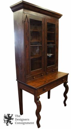 an old fashioned wooden cabinet with glass doors