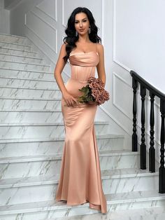 a woman in a long dress standing on some stairs