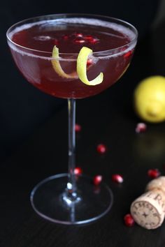 a close up of a wine glass with a drink in it and a cork on the side