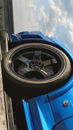 a blue sports car with its tires on the rim