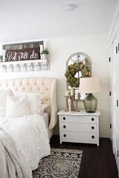 a bedroom with white furniture and decor on the walls