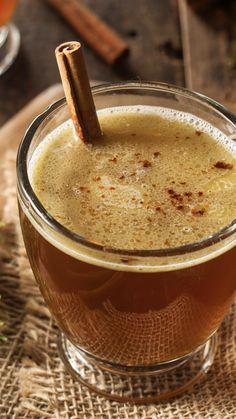 a glass cup filled with liquid and cinnamon stick