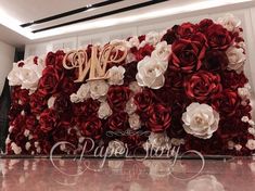 red and white flowers are arranged on the wall