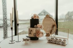 a table topped with a cake next to a mirror and candle holders on top of it