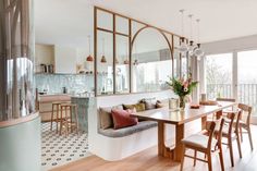 a dining room table with chairs and a bench in front of a large glass window