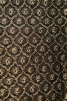 an intricate pattern is shown in black and gold colors on a dark background with white circles