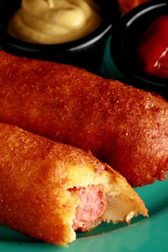 two fried food items on a plate with dipping sauces