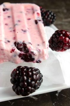 some blackberries and ice cream on a white plate