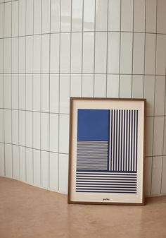 a blue and white art piece sitting on top of a table next to a tiled wall