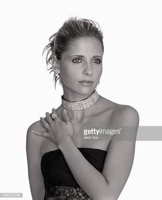 a woman in a strapless dress poses with her hands on her chest