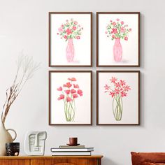 three pink vases with flowers in them are hanging on the wall above a dresser