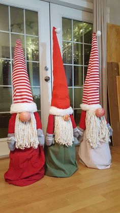 three gnome statues sitting on top of a hard wood floor