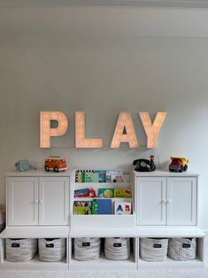 a play area with toys and lights on the wall, including bins for children's toys