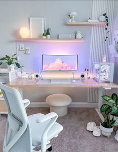 a desk with a computer on it and some plants in the corner next to it