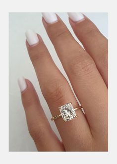 a woman's hand with an engagement ring on it and a diamond in the middle