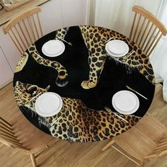 a leopard print table cloth with white plates on it