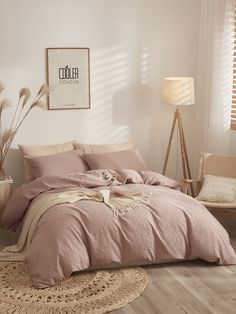 a bed with pink linens in a white room