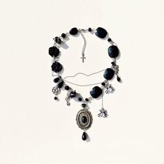 Elevate your Halloween style with this upcycled black gothic necklace adorned with spooky spiders and fascinating pendants. Handcrafted using a mix of plastic and glass beads, this unisex accessory is perfect for adding a touch of mystery to your ensemble. The stainless steel fittings ensure durability while maintaining a modern edge. Stand out this Halloween season with this unique and versatile necklace that exudes a hauntingly chic vibe. ✤length : 14 inch + 1 extender chain (you can add or reduce the length, write to me about it) I am not responsible for any damage or injuries done from wearing this item after shipping, along with any stones coming loose or breakage. ✤ It is a Vintage item and there is some wear and tear on it, but that is why it is an assemblage and it adds charm and c Spooky Necklace, Spooky Spiders, Stainless Steel Fittings, Halloween Style, Gothic Necklace, Unisex Accessories, Halloween Fashion, Halloween Jewelry, Halloween Season