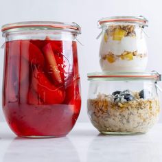 three jars filled with food sitting on top of a white counter next to each other