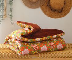 three pillows stacked on top of each other in front of hats and wall hangings