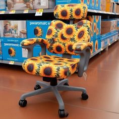 an office chair with sunflowers painted on it in front of shelves at a store