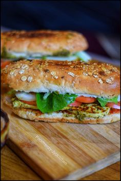 two sandwiches sitting on top of a wooden cutting board