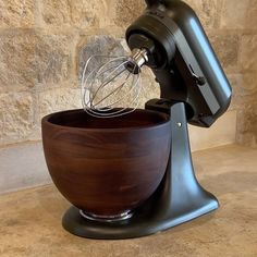 a wooden bowl with an electric mixer in it