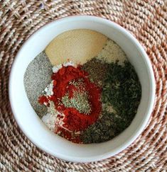 spices and seasonings in a white bowl on a woven place mat, top view