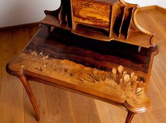 an old wooden bench with flowers painted on the back and sides, sitting on a hard wood floor