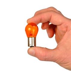 a person holding an orange light bulb in their hand