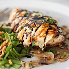 a white plate topped with chicken, mushrooms and veggies next to a fork