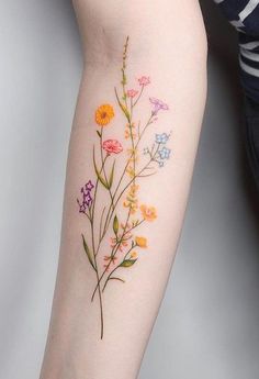 an arm tattoo with flowers on it and the words explore written in bold font below