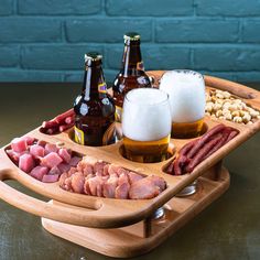 a wooden tray with beer and meats on it