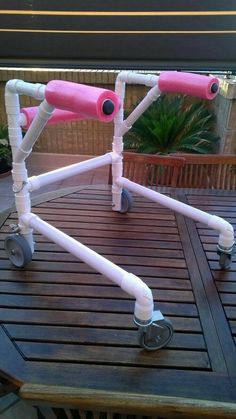 a pink and white walker sitting on top of a wooden table