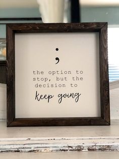 a wooden frame with a quote on it that says the option to stop but the decision to keep going