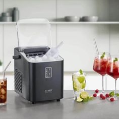 an ice maker sitting on top of a counter next to some glasses and cups filled with drinks