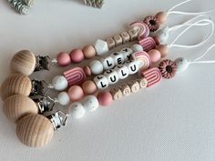 three beaded bracelets with words on them sitting next to other beads and charms