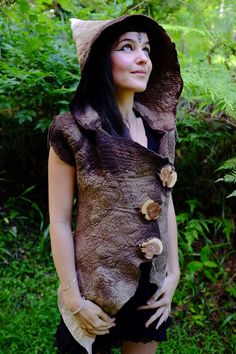 a woman wearing a brown jacket and hat with mushrooms on it