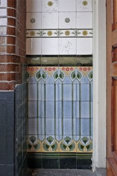 an open door leading to a bathroom with tiled walls