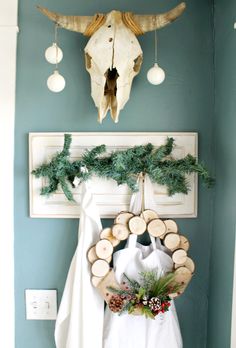 a deer skull hangs on the wall next to a wreath