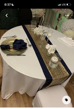 the table is set with white and blue linens, silverware, and flowers