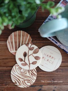 three wooden coasters sitting on top of a table next to a potted plant