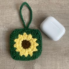 a crocheted square with a sunflower on it next to a white object