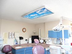 a dentist's office with blue cabinets and purple chairs